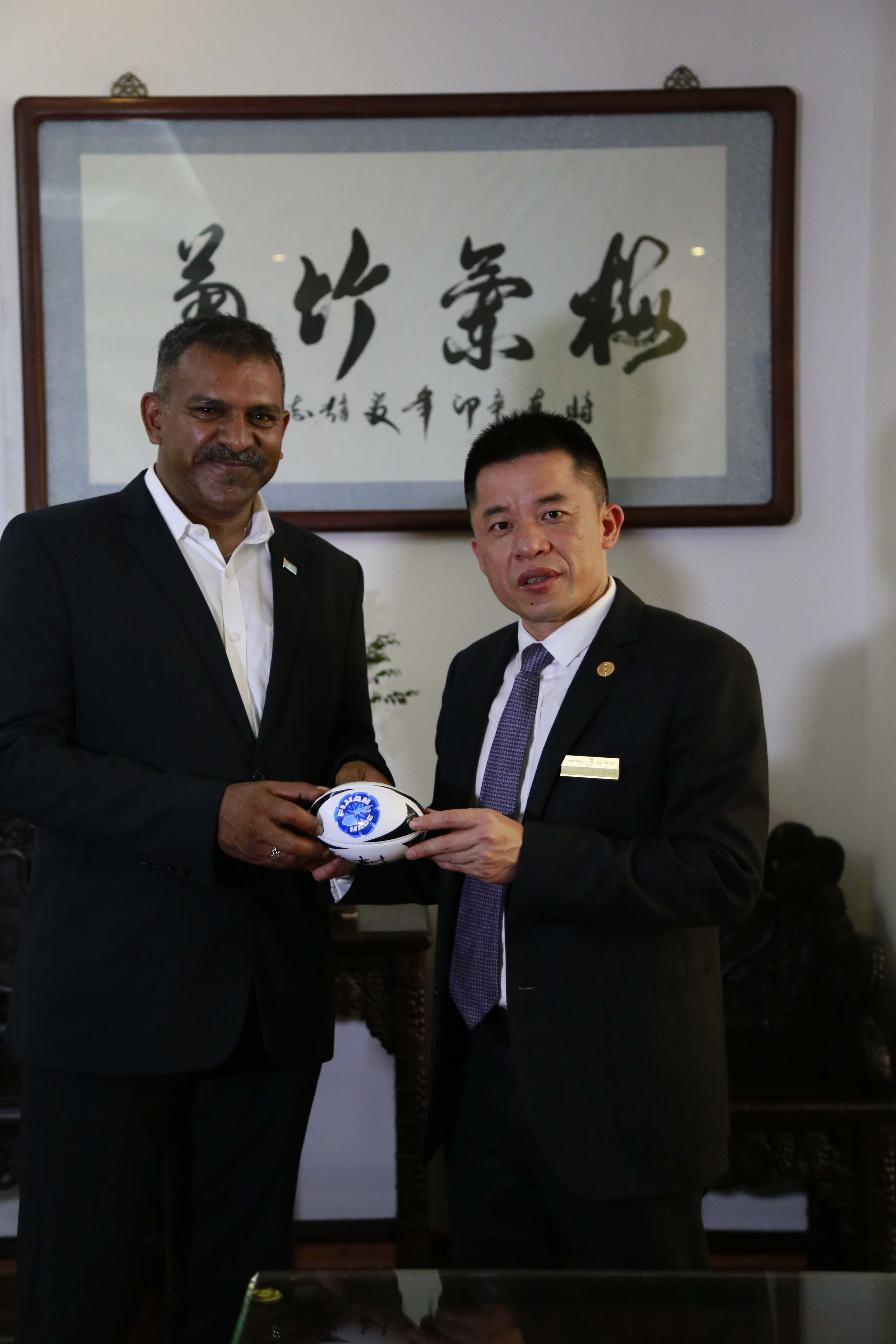 法亚兹·科亚先生和陈玉树先生共同在橄榄球上签名共证友谊天长地久_易速网 26日下午,以斐济工业贸易旅游部部长法亚兹科亚先生、斐济投资局主席特鲁曼拉德利先生和斐济驻上海总领事馆总领事陈玉茹女士等组成的斐济共和国政府代表团对中国造、中国传统红木家具兴趣盎然,慕名前往莆田市四君子古典家具有限公司总部,受到四君子古典家具有限公司董事长陈玉树先生热情接待。 四君子董事长陈玉树(左)为斐济共和国政府代表团介绍红木家具 斐济共和国政府代表团在四君子古典家具有限公司董事长陈玉树的邀请下,参观四君子红木家具展示厅、工厂,并一同观看四君子企业宣传片。四君子红木艺术家具开启了外国友人探寻中国